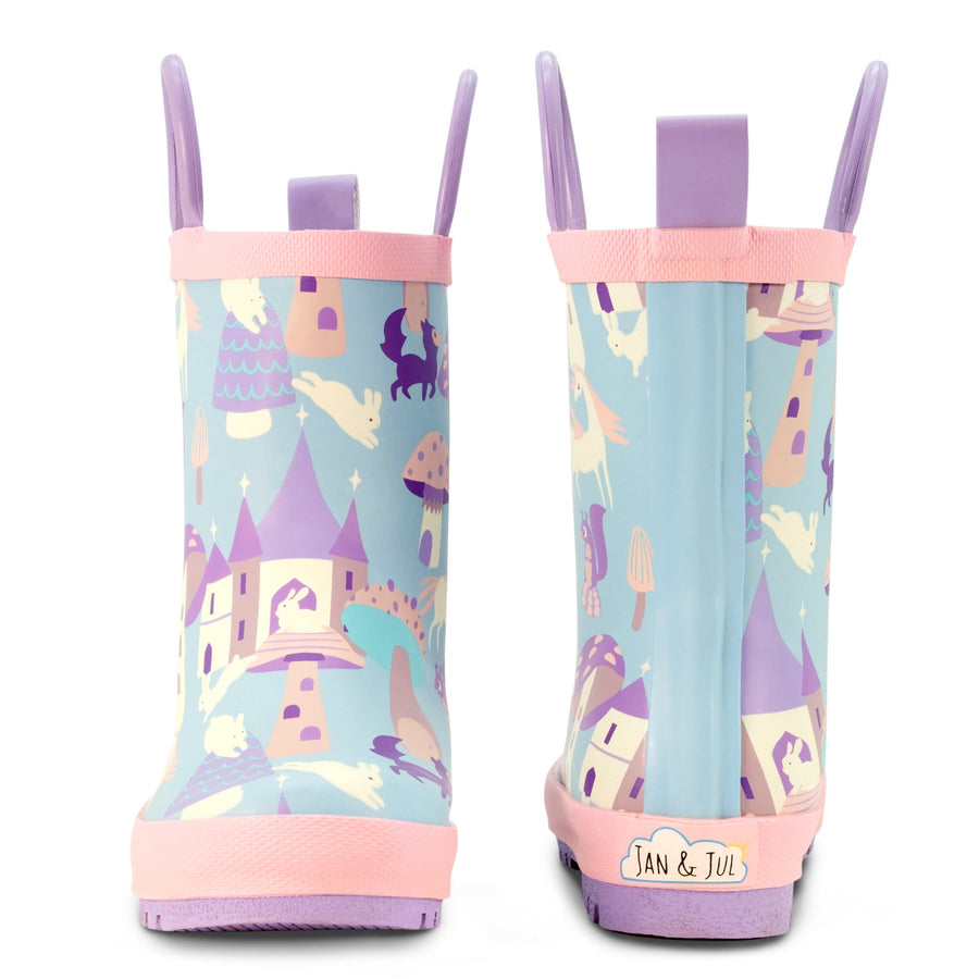 Jan & Jul rain boots with a pastel castle-and-unicorn print, pink trim and purple pull handles.