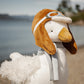 Close-up of a white plush goose wearing a brown aviator hat, goggles and a gray scarf.