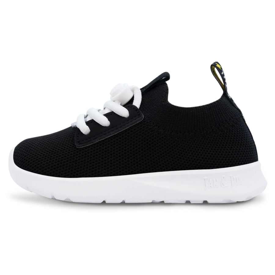 Black Jan & Jul knit-look shoe with white laces and a white sole, side view.