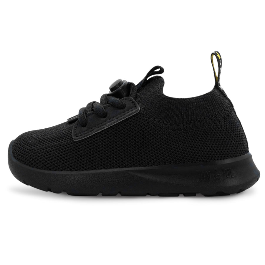 Black Jan & Jul knit-look shoe with black laces and a black sole, side view.