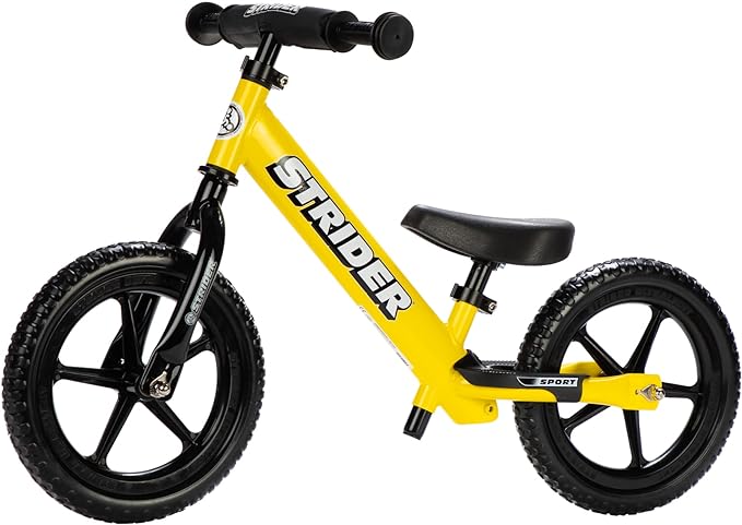 Yellow Strider 12 Sport balance bike shown from the side, with a low seat and no pedals.
