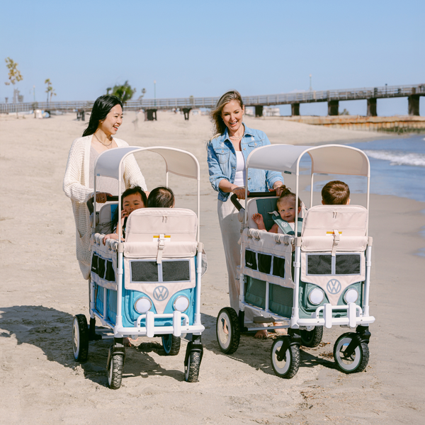 Families at the beach with blue and sage WonderFold Volkswagen collaboration wagons.