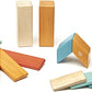 Fourteen Tegu Sunset wooden blocks displayed by shape and color.