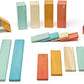Twenty-four Tegu Sunset wooden blocks displayed by shape and color.