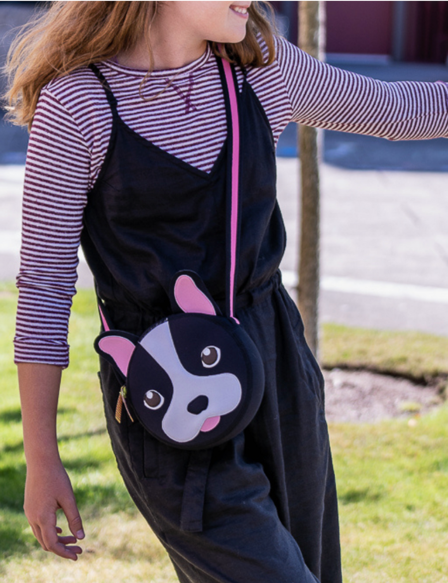 Child wearing a black Dabbawalla French Bulldog crossbody bag with pink ears.
