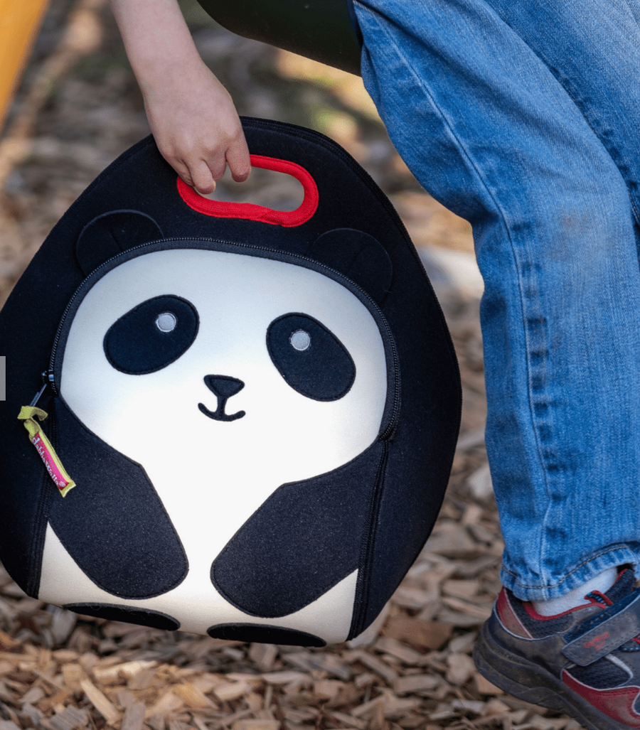 Hand holding a black-and-white Dabbawalla Panda Bear lunch bag with a red handle.