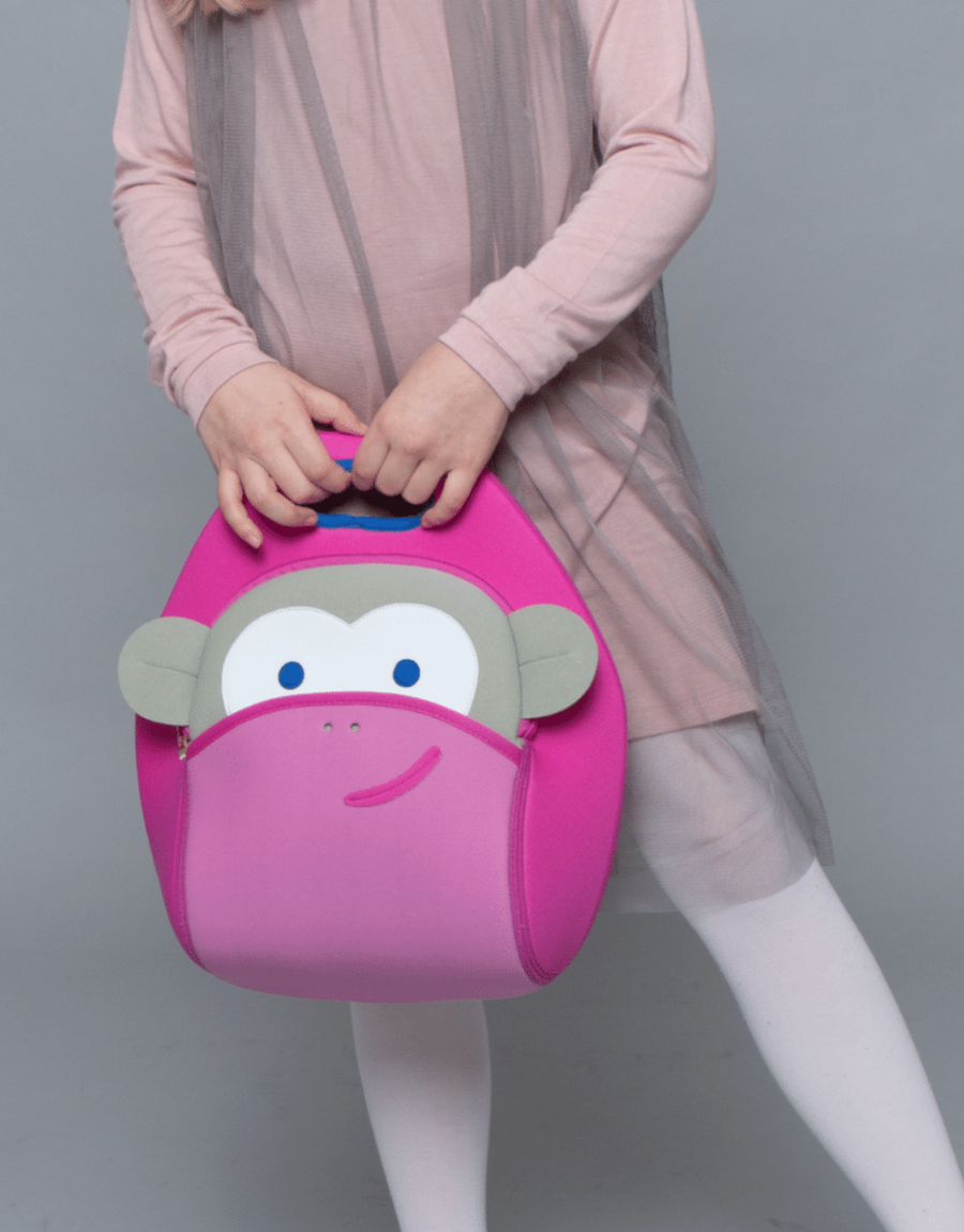 Child holding a pink Dabbawalla Pink Monkey lunch bag by its top handle.